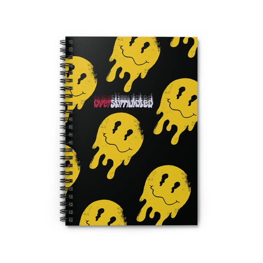 Black spiral notebook with yellow melting smiley faces repeating pattern. Text reads "overstimulated" in red and white. Edgy and playful design.