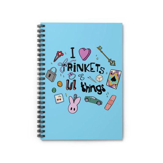 Blue notebook cover with playful illustrations, including a heart, key, dice, flower, and text: "I love trinkets & lil things." Whimsical and fun design.