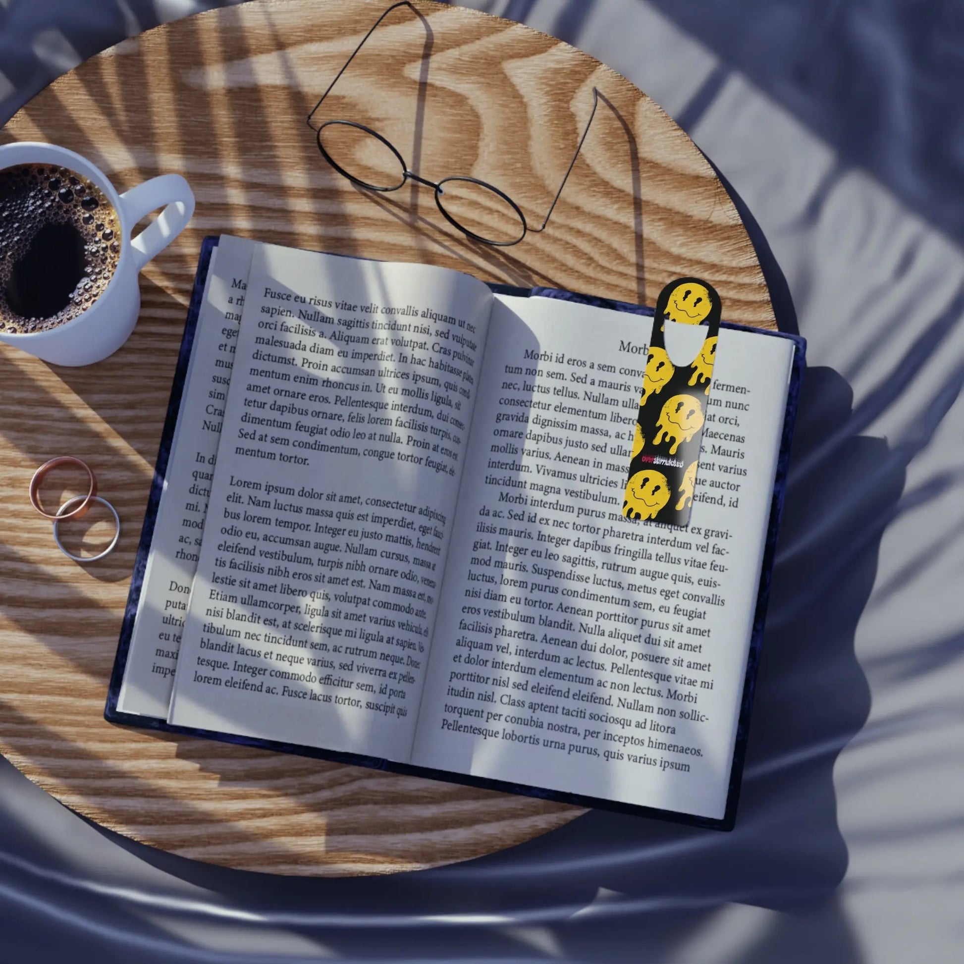 Open book with a smiley face bookmark lies on a wooden table. 
