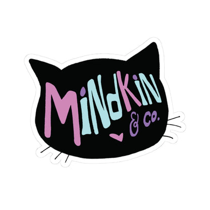 Vibrant, colorful sticker reading "Mindkin & co." in bright pink and blue on a black cat head silhouette background. The cat head has a small pink heart to represent it's nose. Playful, bold font with a small heart symbol.