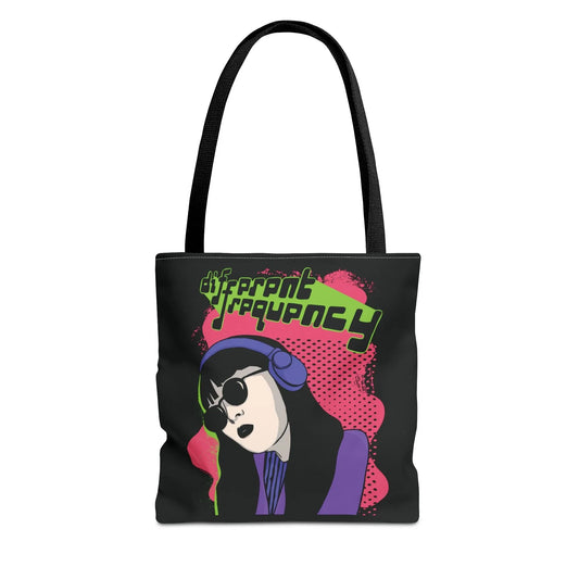 Illustrated black tote bag with a stylish person wearing headphones and sunglasses on a pink background. Text reads "different frequency." Retro vibe.