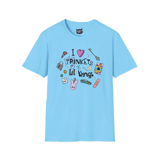 Blue T-shirt featuring doodles of ornate keys, dice, a toy car, a flower hairclip, a postage stamp, a butterfly ring, and a pink bunny keychain. Text reads "I love trinkets and lil things" with playful, colorful illustrations.