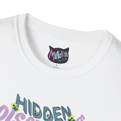 Close-up of a white T-shirt with ribbed collar and "Mindkin & Co." label in colorful letters. Below, partial view of "Hidden" text with small, colorful flowers.