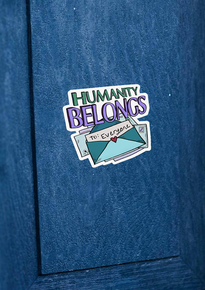 Humanity Belongs sticker on a textured blue surface reads "Humanity Belongs" with an envelope illustration labeled "To: Everyone" featuring a small heart, conveying inclusivity.