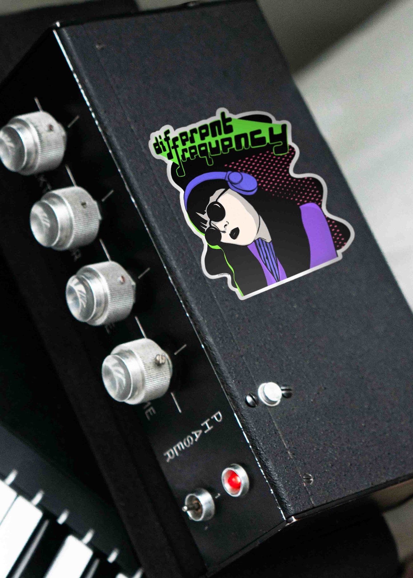 Glossy, scratch-resistant Different Frequency sticker seen on a music equipment item.